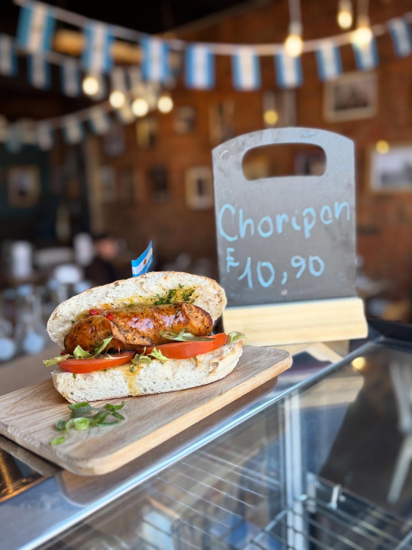 Choripán — grilled chorizo in crusty bread with tomato and salad